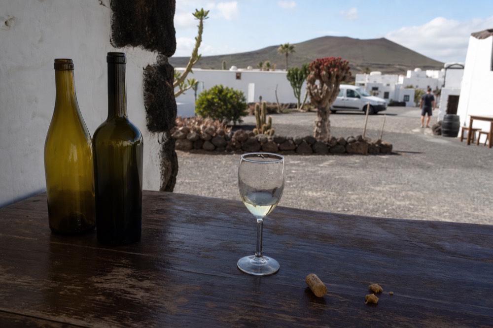 Bottles of Lanzarote wine on a table with a glass of white wine