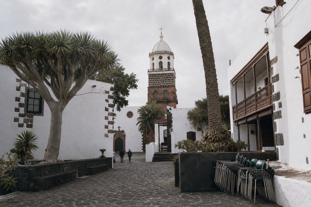 Whitewashed church and stone houses in a historic Canarian town square