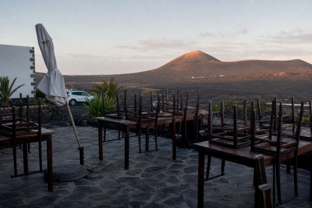 Empty terrace at a winery with volcano in the distance, early morning light