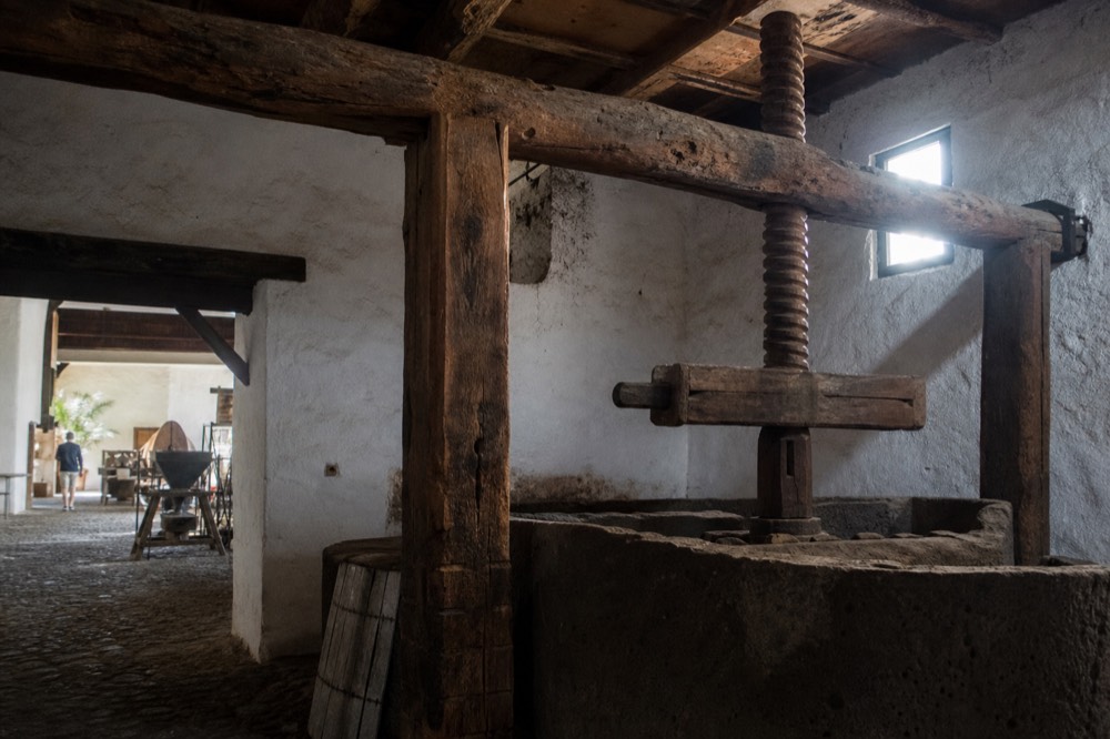Old stone wine press and wooden beams inside a historic Lanzarote winery